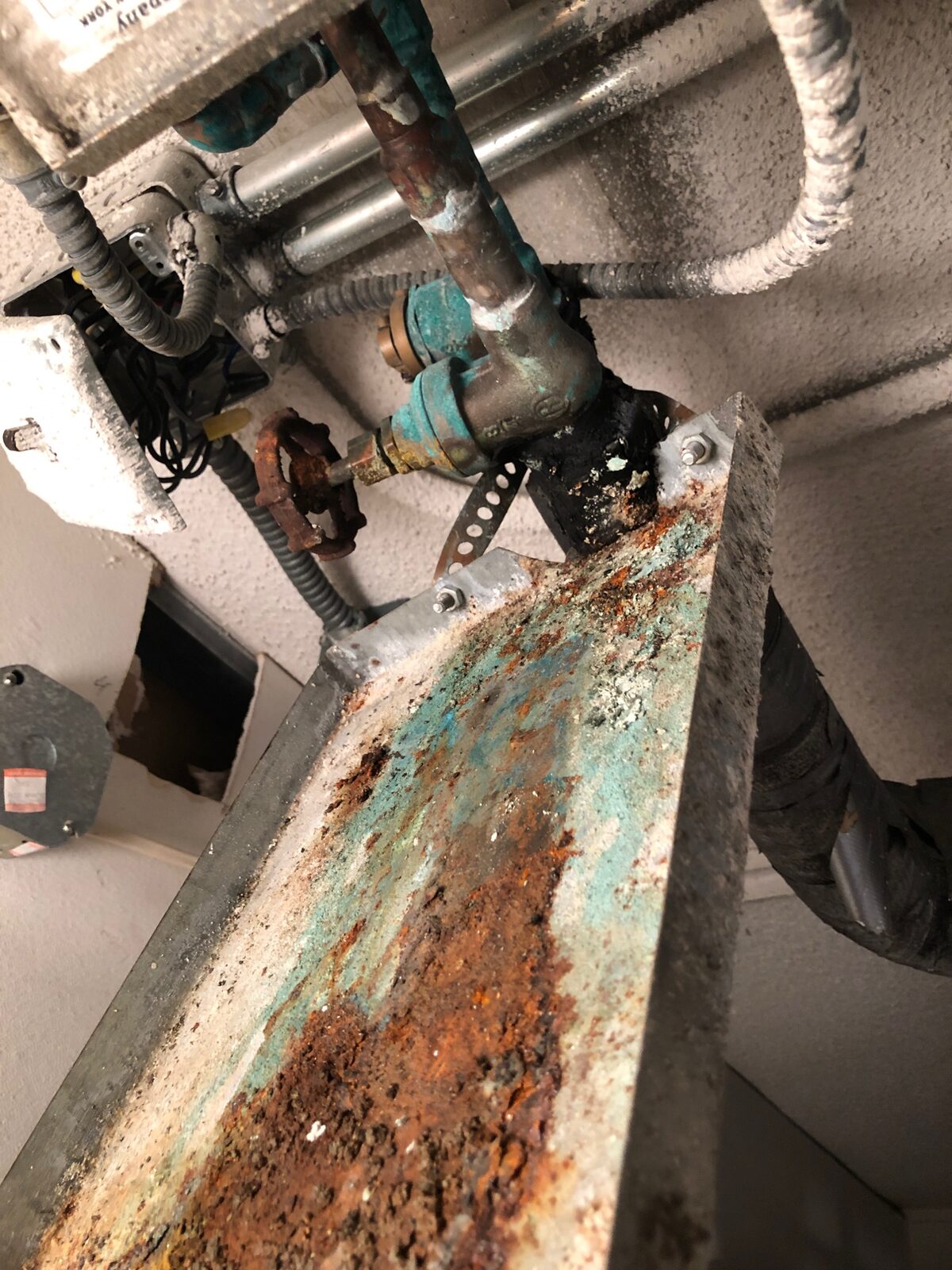 Rusted refrigerant piping and valves photographed up close