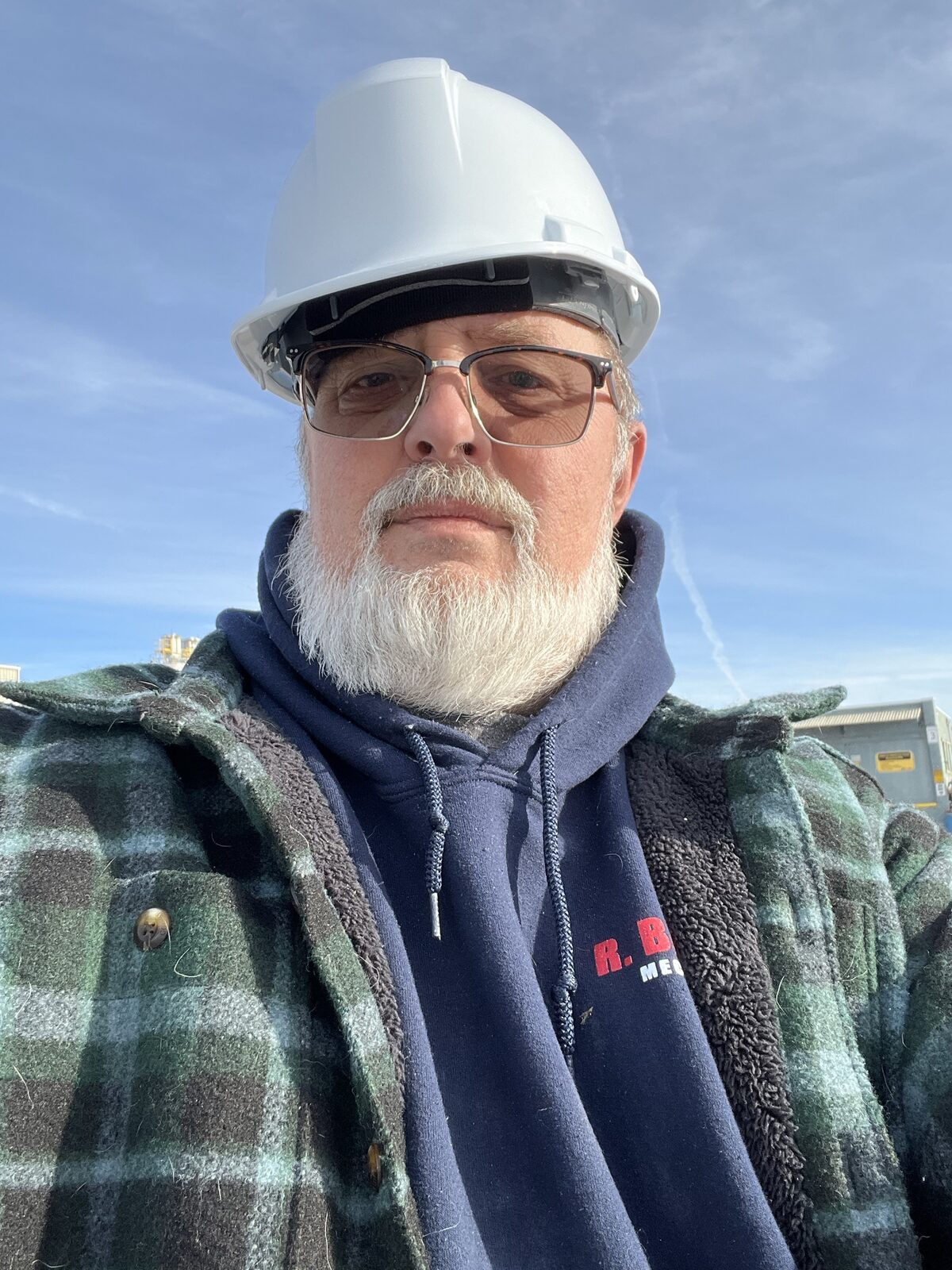 Gregory Frazier, the Home Whisperer, in a hard hat and flannel on a job site