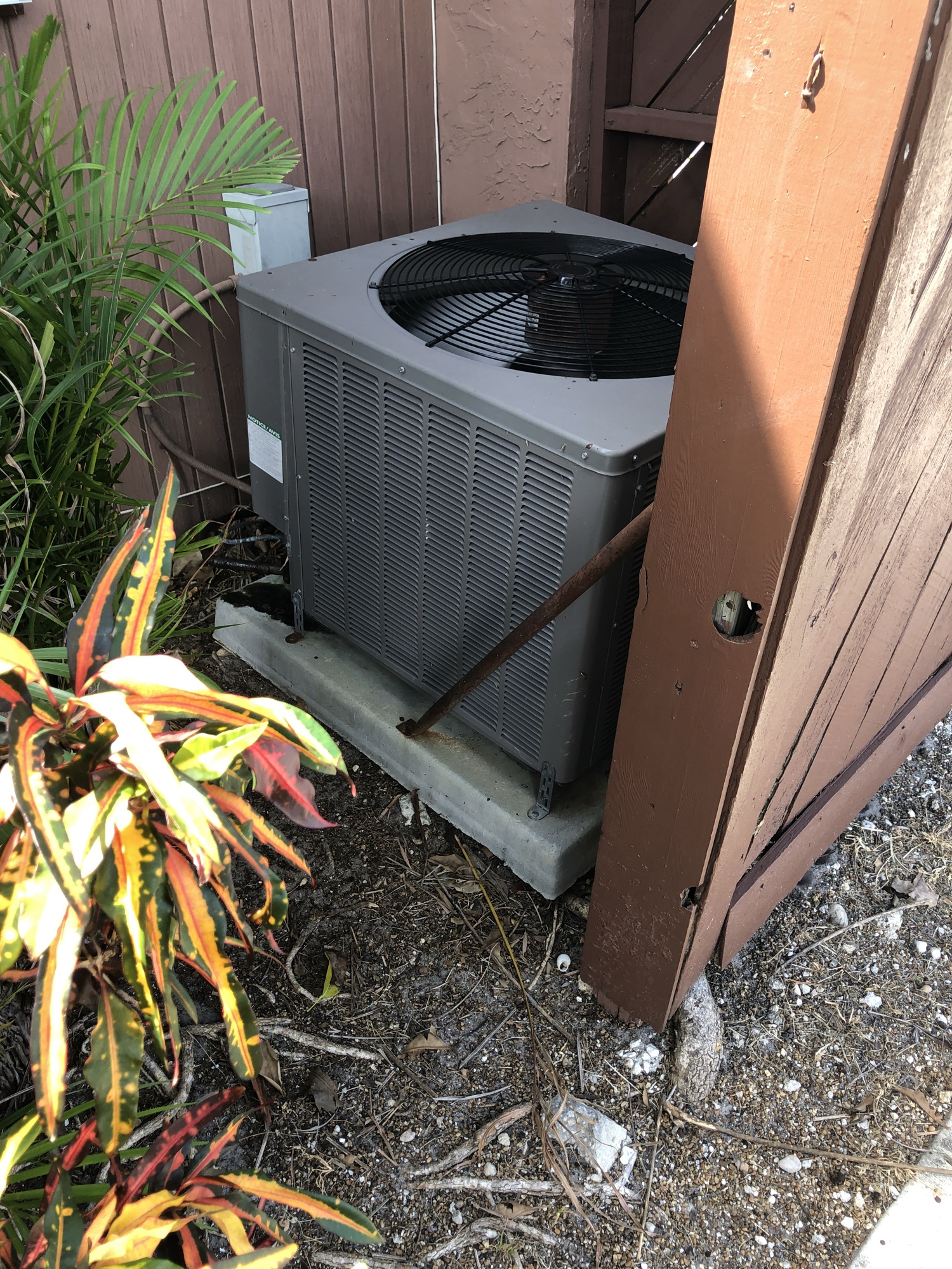 Residential condensing unit beside a home